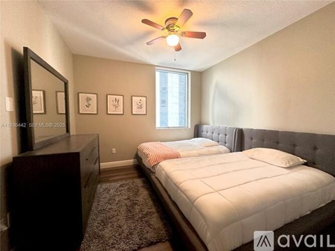 A bedroom with a bed, dresser, and mirror.