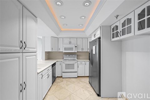 A kitchen with white cabinets and appliances.