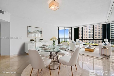 A modern dining room with a glass table and white chairs.