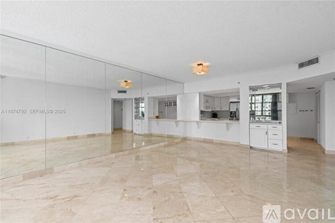 A spacious room with marble flooring and a glass wall.