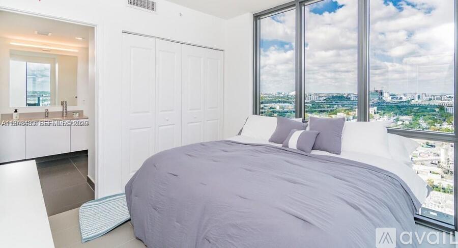A bedroom with a large bed and a view of the city.