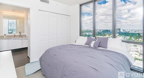 A bedroom with a large bed and a view of the city.