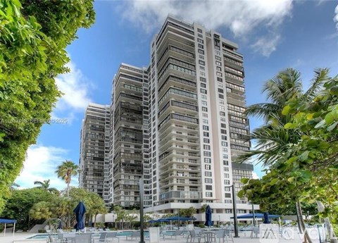 A tall residential building with a pool in front.
