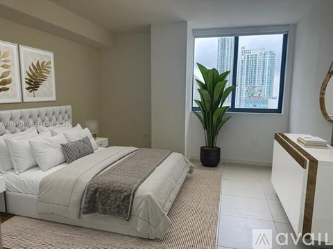 A bedroom with a large bed and a potted plant.