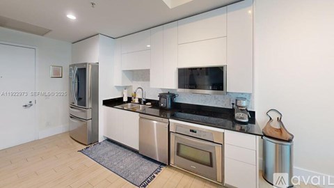 A modern kitchen with stainless steel appliances and white cabinets.