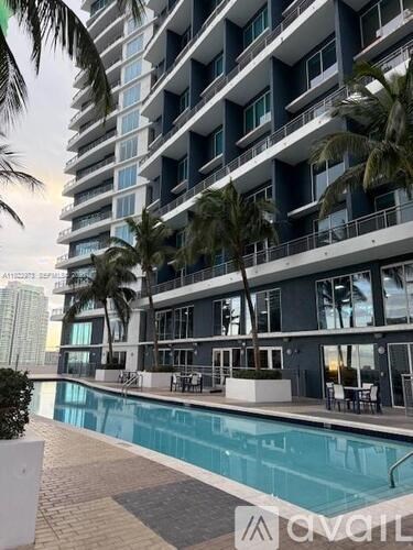 A modern apartment building with a pool in front.