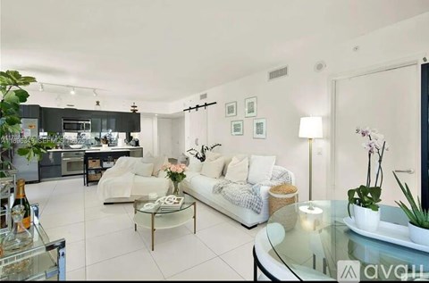 A modern living room with a white sofa and a glass coffee table.