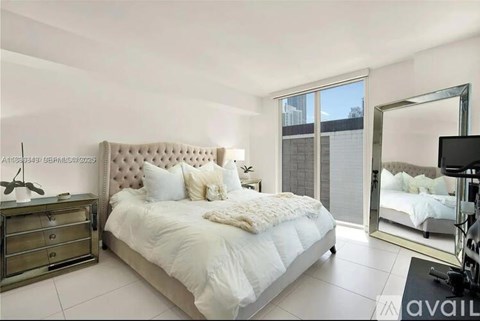 A bedroom with a large bed, a mirror, and a dresser.