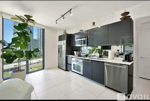 A modern kitchen with a large window and a view of the city.