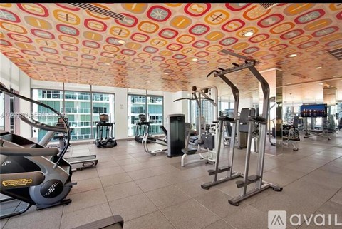 A gym with a variety of equipment including treadmills, stationary bikes, and weight machines.