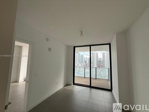 A spacious room with a view of the city through large windows.
