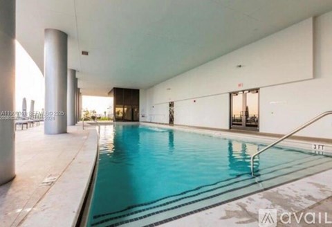 A large indoor swimming pool with a ladder on the right side.