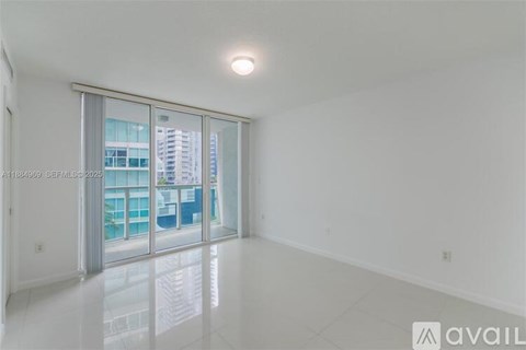 A spacious, empty room with a large window and a sliding glass door.