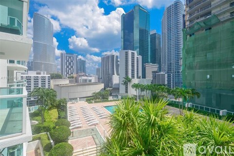 A view of a cityscape with tall buildings and a pool in the foreground.