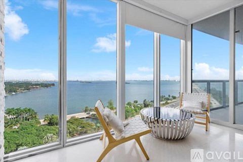 A room with a view of the water and sky through large windows.