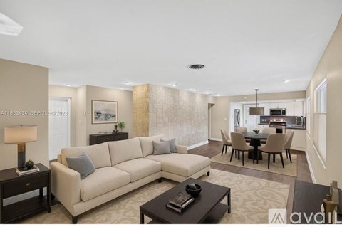 A living room with a beige sofa, a coffee table, and a dining table set up.