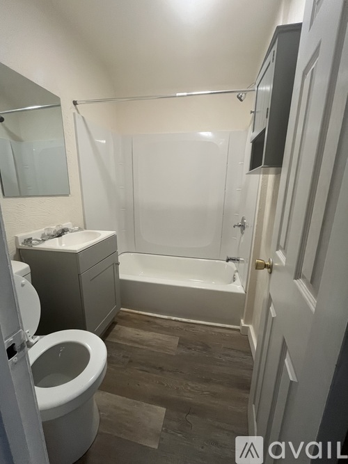 A room with wooden flooring and a window letting in light.
