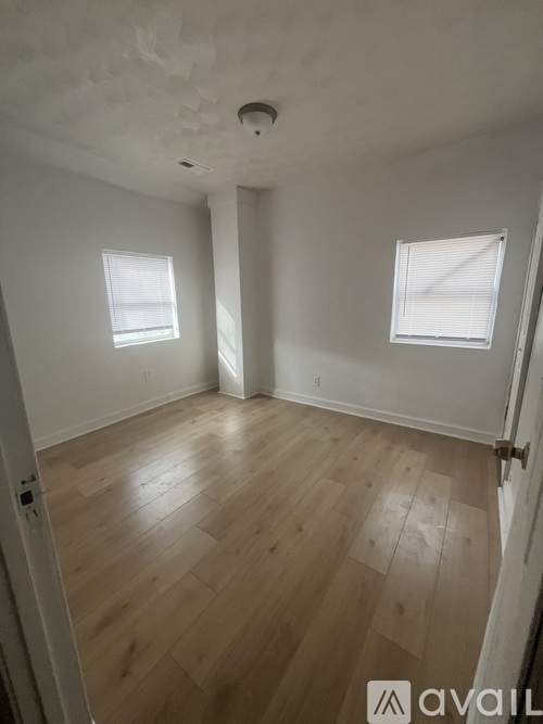 A room with wooden flooring and a window.