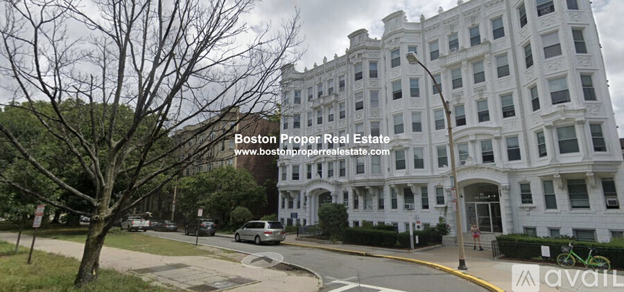 A street view of a large white building with the text "Boston Proper Real Estate" and a website address.