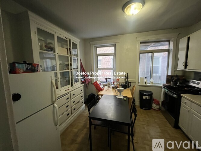 A kitchen with white cabinets and a black table.
