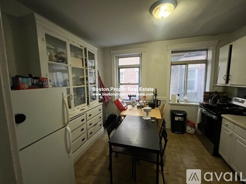 A kitchen with white cabinets and a black table.