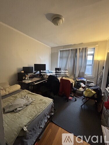 A bedroom with a bed, desk, and chair.