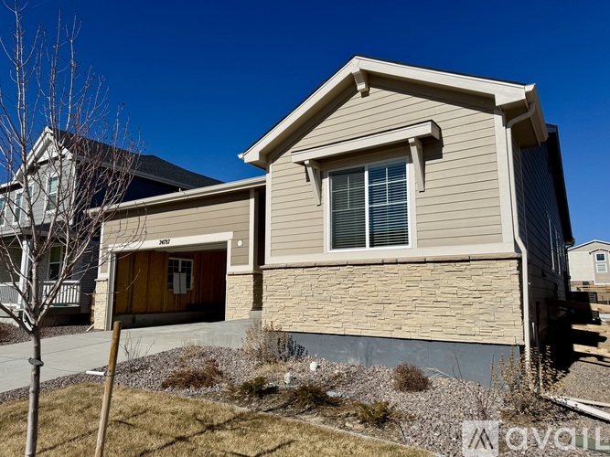 A house with a brown and beige exterior and a brown door.