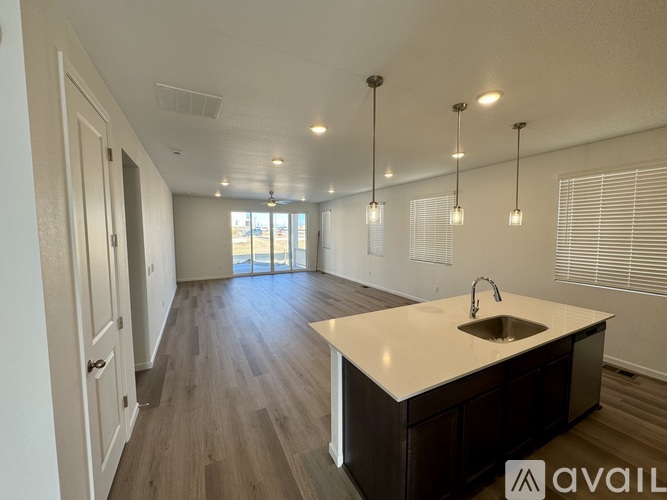 A kitchen with a sink and wooden floors.