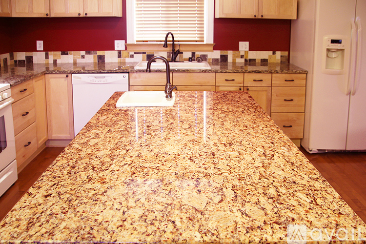A kitchen with a granite counter top and a white dishwasher.