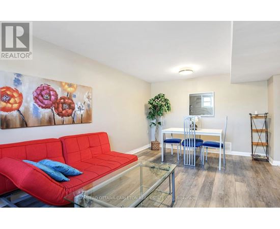 A living room with a red couch and a glass coffee table.