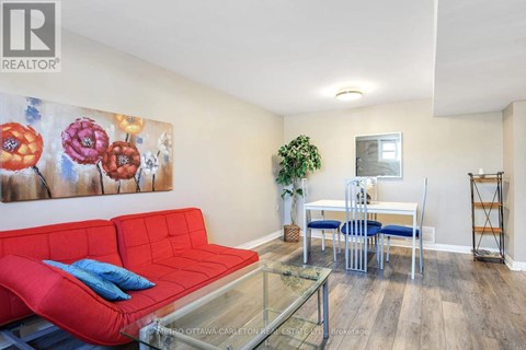 A living room with a red couch and a glass coffee table.
