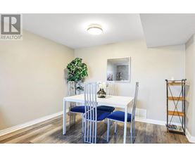 A dining room with a white table and blue chairs.