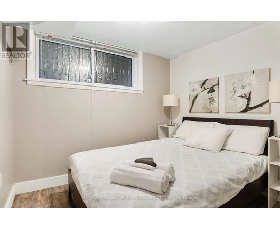 A bedroom with a bed, two lamps, and a window.