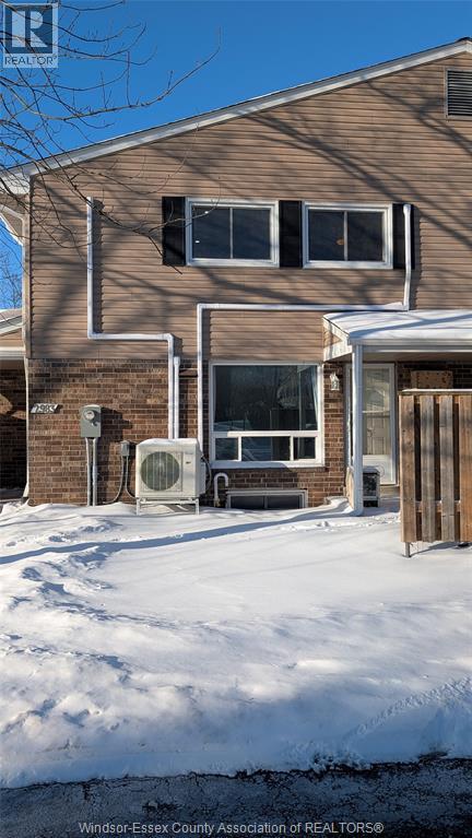 A house with a snow covered ground in front of it.