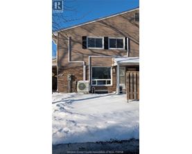 A house with a snow covered ground in front of it.