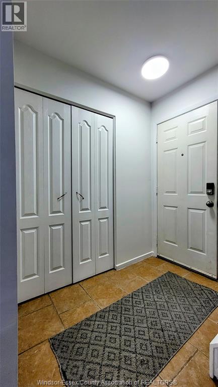 A hallway with a rug and two doors.