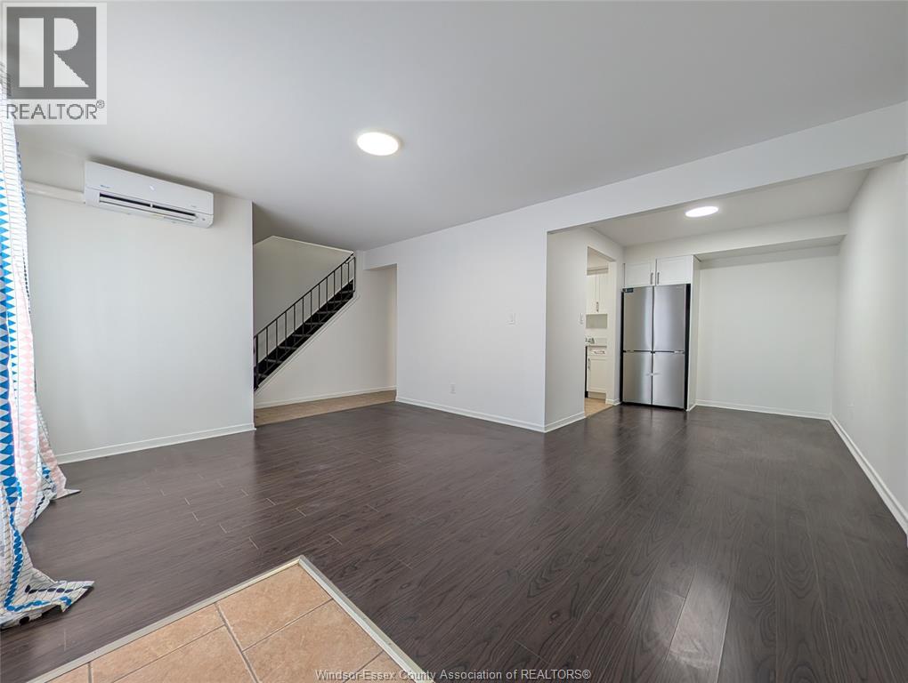 A room with wooden flooring and white walls.