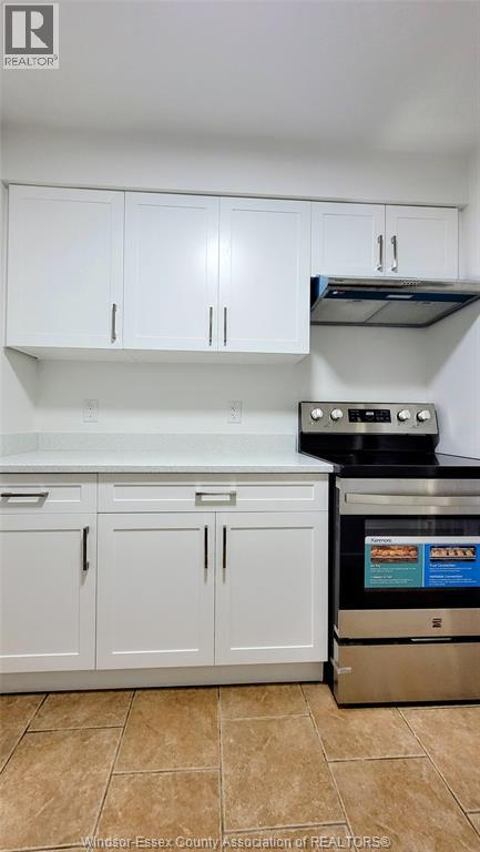 A kitchen with white cabinets and a stainless steel dishwasher.