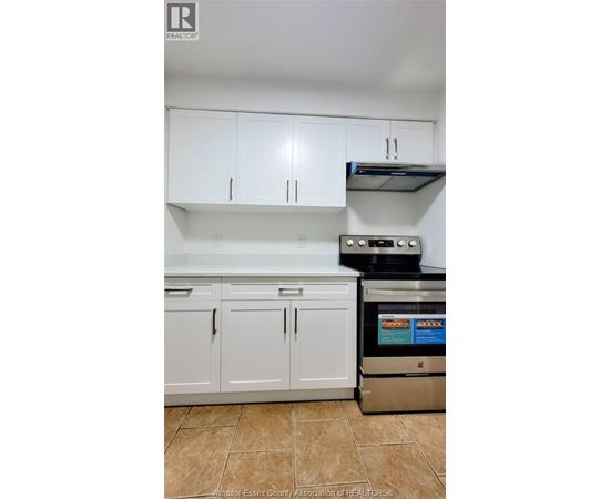 A kitchen with white cabinets and a stainless steel dishwasher.