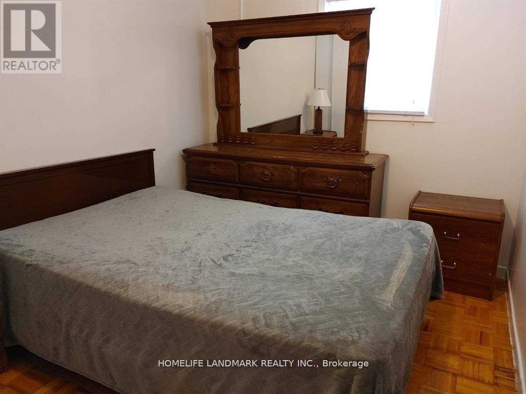 A bedroom with a bed, dresser, and mirror.