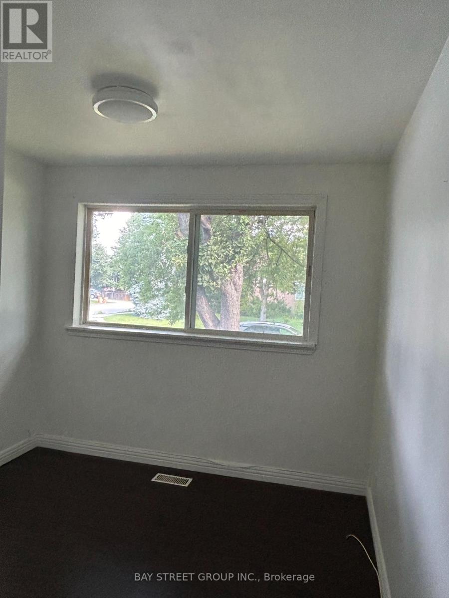 A room with a window showing trees outside.