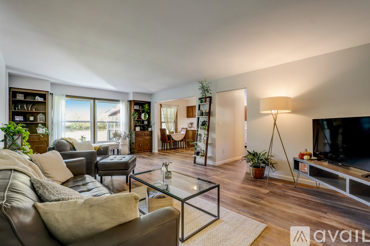 A living room with a glass coffee table and a large leather couch.