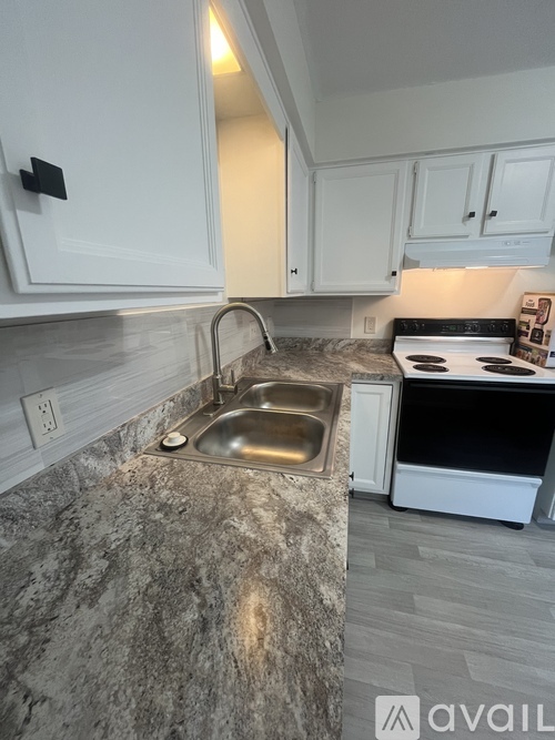 A kitchen with a granite countertop and white cabinets.