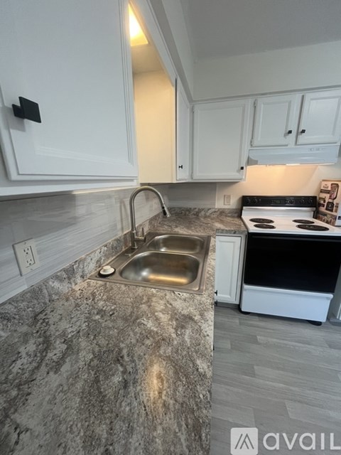 A kitchen with a granite countertop and white cabinets.