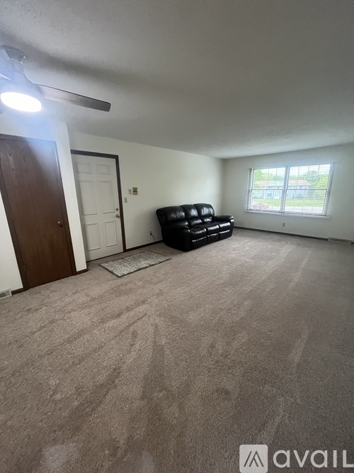 A living room with a couch and a window.