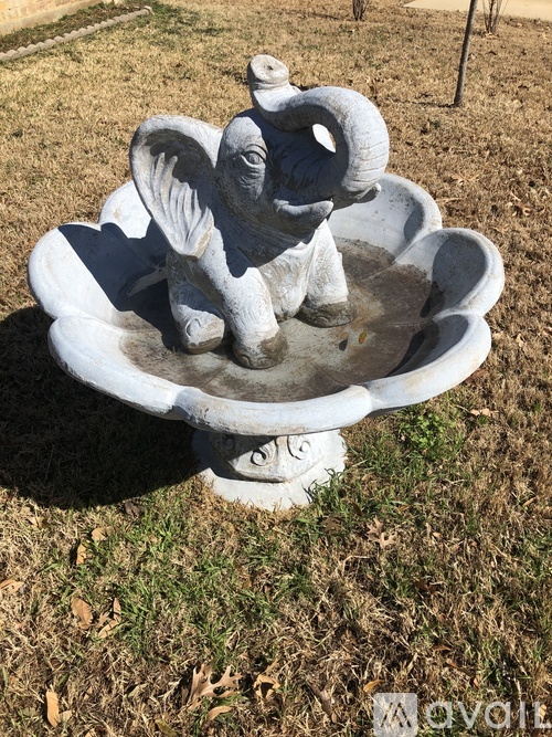 A stone statue of an elephant sitting on a pedestal.