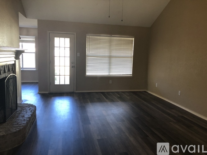 A room with wooden floors and a window with blinds.