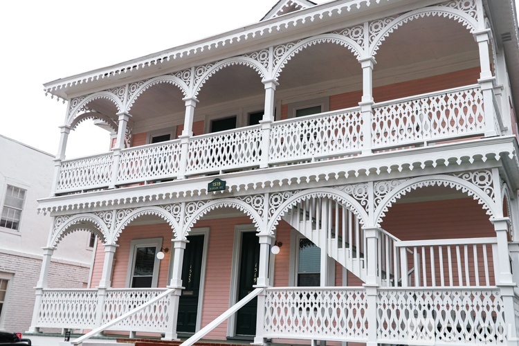 A white balcony with a black railing.