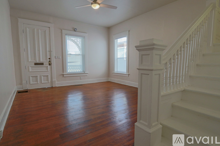 A room with wooden floors and a staircase.