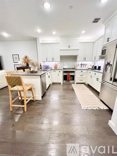 A kitchen with white cabinets and a wooden chair.